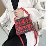 The New Retro Checered Bag Is A One-Oulder Handbag With A Red White And Blue Gluig Stic Bag Under The Armpits